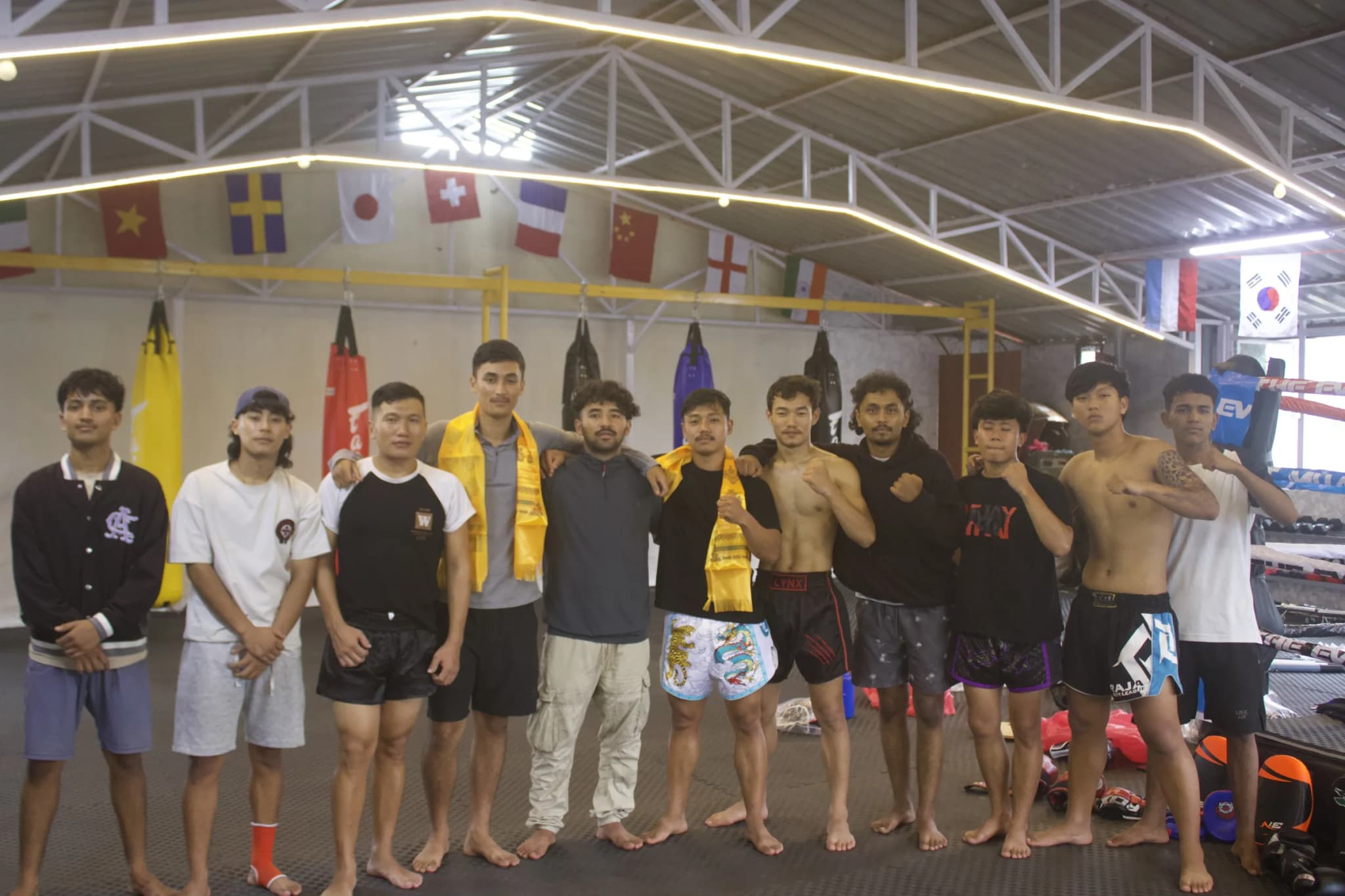 The team at The Everest Muay Thai lined up under the international flags